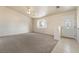 Bright living room with neutral carpet and tiled entry near a white front door with decorative glass at 480 China St, Pahrump, NV 89048