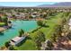 Scenic aerial view of a lush community with a serene lake, golf course, and beautiful homes at 4909 Ocean Shores Way, Las Vegas, NV 89130