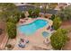 Resort style community pool and spa with lounge chairs and mature trees at 4909 Ocean Shores Way, Las Vegas, NV 89130