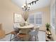 Cozy dining room with a round table, modern chandelier, and bright natural light at 4909 Ocean Shores Way, Las Vegas, NV 89130