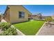 This landscaped backyard features artificial turf and a patio with a dining area for relaxing outdoors at 498 Pebble Run Ave, Henderson, NV 89011