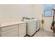 Bright laundry room featuring a clean countertop, modern washer, and modern dryer at 498 Pebble Run Ave, Henderson, NV 89011