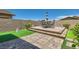 This backyard patio area features pavers, artificial turf and an outdoor dining space at 498 Pebble Run Ave, Henderson, NV 89011