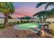 Serene backyard with pool, spa, desert landscaping, and a outdoor kitchen and patio seating at 5350 Sharon Marie Ct, Las Vegas, NV 89118
