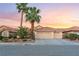 Charming single-story home with a three car garage, desert landscaping, and a red tile roof at sunset at 5350 Sharon Marie Ct, Las Vegas, NV 89118