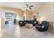 Bright living room with tile flooring, a vaulted ceiling, ceiling fan, and comfortable black leather seating at 5350 Sharon Marie Ct, Las Vegas, NV 89118