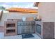 Well-equipped outdoor kitchen with stainless steel grill, tiled countertop, fridge, and storage, great for entertaining at 5350 Sharon Marie Ct, Las Vegas, NV 89118