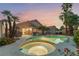Relaxing backyard with pool, spa, patio seating, and beautiful desert landscaping and mature palm trees at 5350 Sharon Marie Ct, Las Vegas, NV 89118