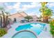 Private backyard featuring a sparkling pool, spa, patio, palm trees, and lush landscaping, creating a serene retreat at 5350 Sharon Marie Ct, Las Vegas, NV 89118