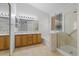 Bright bathroom with a double sink vanity, tile floors, and glass-enclosed shower and separate tub at 538 Ancient Mayan Dr, Henderson, NV 89015