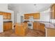 Bright eat-in kitchen featuring tile floors, an island, modern appliances and oak cabinets at 538 Ancient Mayan Dr, Henderson, NV 89015