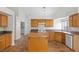 Bright eat-in kitchen featuring tile floors, an island, modern appliances and oak cabinets at 538 Ancient Mayan Dr, Henderson, NV 89015