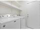 The bright laundry room includes a modern washer and dryer, plus upper cabinets for storage at 538 Ancient Mayan Dr, Henderson, NV 89015