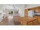 Open living room with vaulted ceiling, tile floors, fireplace, and kitchen with island and white appliances at 538 Ancient Mayan Dr, Henderson, NV 89015