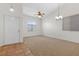 Bright and spacious living room featuring neutral carpet, large windows, and a stylish ceiling fan and light fixture at 538 Ancient Mayan Dr, Henderson, NV 89015