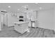 Bright kitchen featuring white cabinets, an island, stainless appliances, and plank flooring at 5580 Waltham Ln, Las Vegas, NV 89122