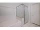 Bathroom showcases tub with shower and glass enclosure, complemented by a white tiled wall at 602 Painted Cloud Pl, Las Vegas, NV 89144