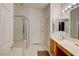 Bright bathroom with white tile, shower, tub, and natural wood vanity at 602 Painted Cloud Pl, Las Vegas, NV 89144