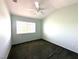 A bright and airy bedroom featuring a ceiling fan, a window with blinds, and neutral colored walls and carpet at 602 Painted Cloud Pl, Las Vegas, NV 89144