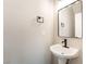 Powder room with pedestal sink, modern faucet, and dark hardware at 6260 Castle Kennedy St, Henderson, NV 89011