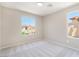 Neutral bedroom featuring carpeted floors and multiple windows with exterior views of neighborhood residences at 6260 Castle Kennedy St, Henderson, NV 89011