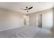 Bedroom offers neutral carpet, ceiling fan, and access to closet and doorway at 6260 Castle Kennedy St, Henderson, NV 89011