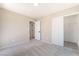 Bedroom with neutral walls and carpeted floors featuring an open closet with sliding doors at 6260 Castle Kennedy St, Henderson, NV 89011