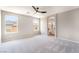Spacious bedroom features neutral carpet, ceiling fan, and two large windows at 6260 Castle Kennedy St, Henderson, NV 89011