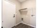 Bright laundry room features modern door, neutral walls, wood look floor, and functional shelving at 6260 Castle Kennedy St, Henderson, NV 89011