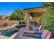 Relax in this backyard oasis with a sparkling pool, covered patio, lounge chairs, and lush landscaping at 6440 Bristlebird St, North Las Vegas, NV 89084