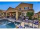 Spacious backyard with a pool, spa, covered patio with seating, and well-maintained landscaping at 6440 Bristlebird St, North Las Vegas, NV 89084