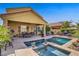 Beautiful backyard with a pool, spa, covered patio, lush plants, and mature trees, ideal for outdoor living at 6440 Bristlebird St, North Las Vegas, NV 89084