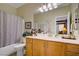Bathroom with tub and shower combo and single sink vanity with wood cabinets at 6440 Bristlebird St, North Las Vegas, NV 89084