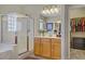 Bathroom features a shower with a glass door, garden tub, and honey colored cabinets at 6440 Bristlebird St, North Las Vegas, NV 89084