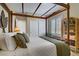 Bedroom with four-poster bed, rattan bookshelf, and plantation shutters at 6440 Bristlebird St, North Las Vegas, NV 89084
