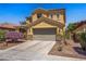 Inviting two-story house with a desert landscape, attached two-car garage, and tile roof at 6440 Bristlebird St, North Las Vegas, NV 89084