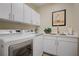Convenient laundry room with modern washer, dryer, sink and white cabinets at 6440 Bristlebird St, North Las Vegas, NV 89084