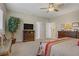 Bright primary bedroom featuring a leafy indoor plant, a television, and shuttered windows at 6440 Bristlebird St, North Las Vegas, NV 89084