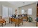 Bright home office features two wooden desks, plantation shutters, and neutral walls and carpet at 6440 Bristlebird St, North Las Vegas, NV 89084