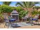 Cozy outdoor seating area with a fireplace, chairs, and views of landscaped backyard at 6440 Bristlebird St, North Las Vegas, NV 89084