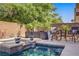 Inviting pool and spa with water feature, surrounded by lush landscaping for a private oasis at 6440 Bristlebird St, North Las Vegas, NV 89084