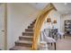 Carpeted staircase with wooden banister and adjacent decorative furniture at 6440 Bristlebird St, North Las Vegas, NV 89084