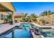 Outdoor pool, spa, and lounging area with a fire pit and drought resistant landscaping at 6440 Bristlebird St, North Las Vegas, NV 89084