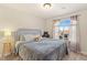 Cozy bedroom featuring soft lighting, plush bedding, and a large arched window with natural light and neighborhood views at 6714 Flamenco Ct, Las Vegas, NV 89139