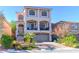 Inviting two-story home with a charming balcony, brick driveway, and lush landscaping at 6714 Flamenco Ct, Las Vegas, NV 89139