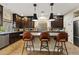 Modern kitchen featuring dark wood cabinets, a breakfast bar, and stainless steel appliances at 6714 Flamenco Ct, Las Vegas, NV 89139