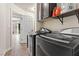 Laundry room with modern washer and dryer units, upper cabinets, and neutral paint, creating a functional space at 6714 Flamenco Ct, Las Vegas, NV 89139