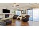 Bright living room features a fireplace, ceiling fan, and wood-look flooring with large windows offering natural light at 6714 Flamenco Ct, Las Vegas, NV 89139