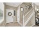 Bright entryway featuring a white door with wreath, neutral walls, and staircase leading to the upper level at 6869 Desert Thrasher Dr, North Las Vegas, NV 89084