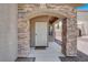 Charming front porch with stone accents and a decorative front door at 6869 Desert Thrasher Dr, North Las Vegas, NV 89084